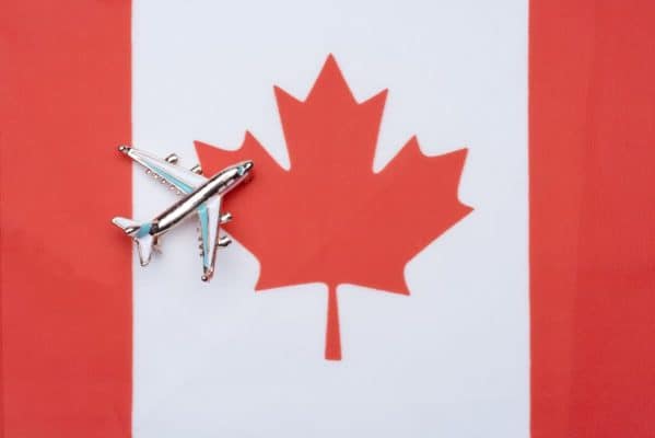 Canada flag and the plane. The concept of travel. Toy airplane on the flag of Canada.